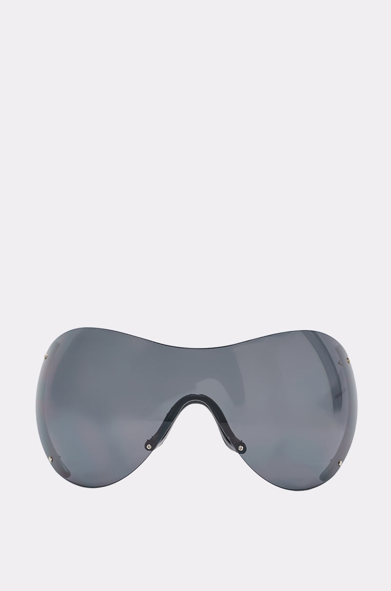 The CAN’T SEE ME SUNGLASSES feature a large, single-piece curved shield design with dark tinted lenses and no visible frame, shown against a plain white background.