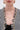A woman wears the INVITE ONLY CHAIN TRIM BLAZER with a houndstooth pattern and gold chain trim, bold gold hoop earrings, and a black lace top. The photo is cropped just below her nose.