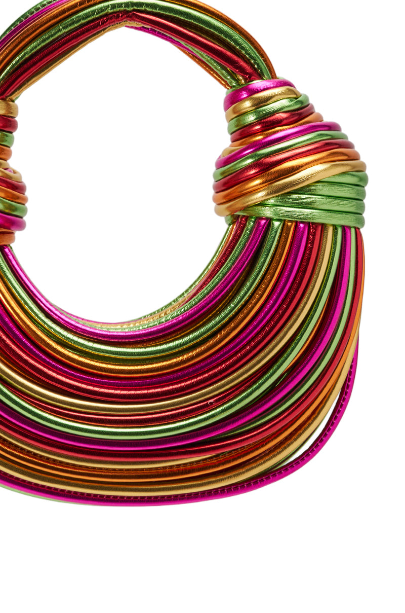 The COAST TO COAST ROPE PURSE is a colorful faux leather handbag with a chunky circular handle and metallic rope detailing in pink, gold, green, and orange for a vibrant striped look. 3