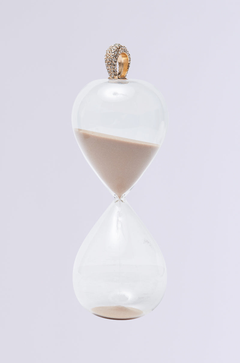 The WE GOT TIME SAND HOURGLASS RING features a rhinestone-encrusted decorative handle and a faux gold finish. The clear hourglass is halfway filled with sand, set against a plain white background to highlight its elegant design. 2