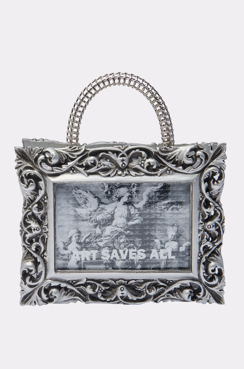 The ART SAVES FRAME BAG is a silver baroque-style purse shaped like a picture frame, featuring a black and white vintage angel image with "ART SAVES ALL" at the bottom—a striking sculptural statement accessory.
