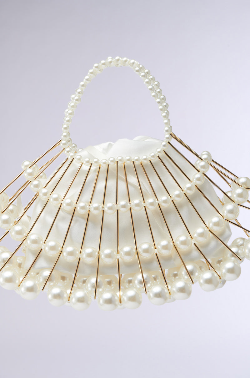 Introducing the DIVINE DREAMS PEARL PURSE: a white handbag showcasing unique gold rod rows and pearlescent fan-patterned beads. Its elegant bead-crafted handle complements its beauty, while a detachable shoulder strap enhances its practicality and allure. 8