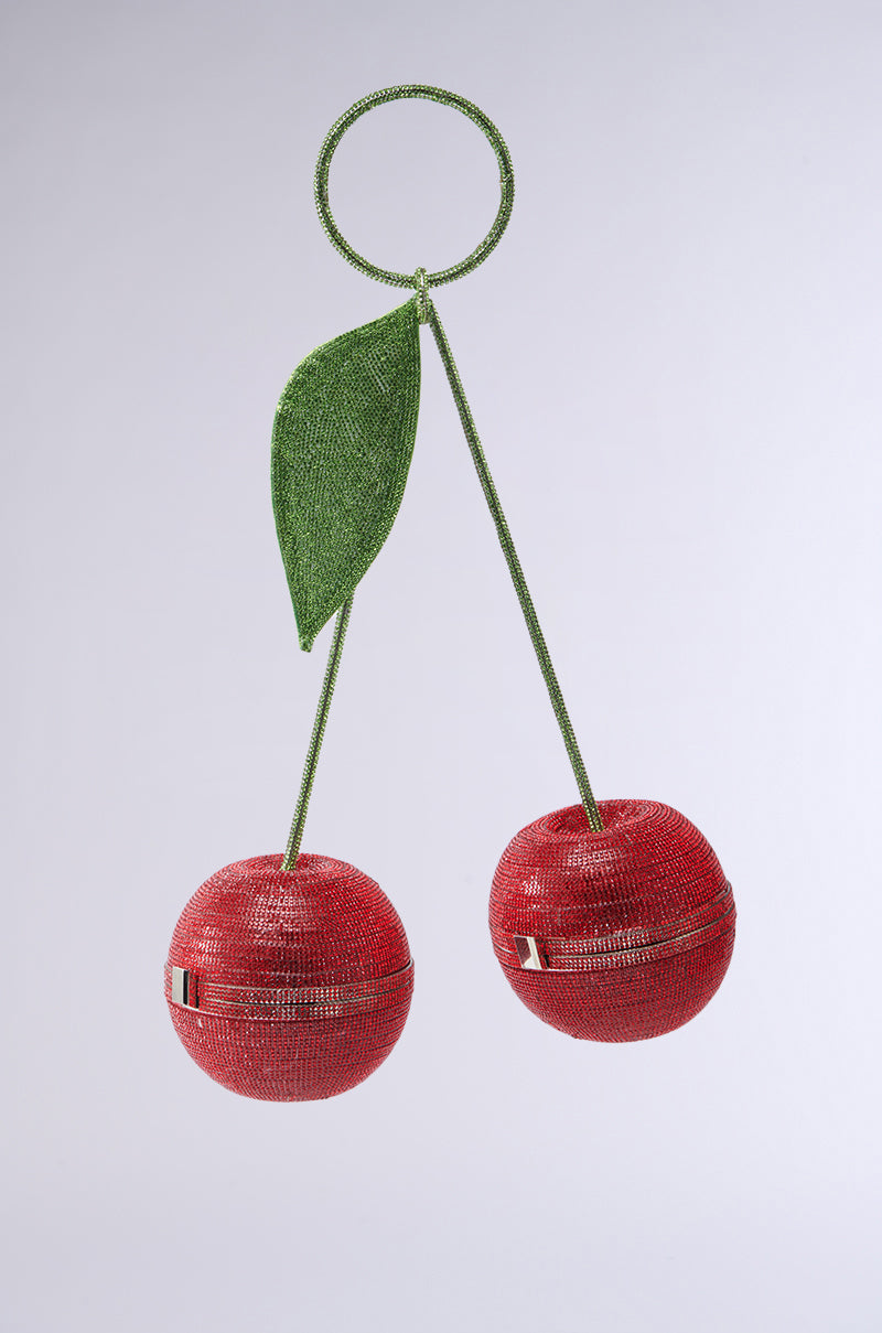 The POP MY CHERRY PURSE features an intricate red bead and rhinestone design, mimicking two cherries with a green stem and leaf. Its handles cleverly resemble a cherry stem, making this accessory both fun and sophisticated. 1