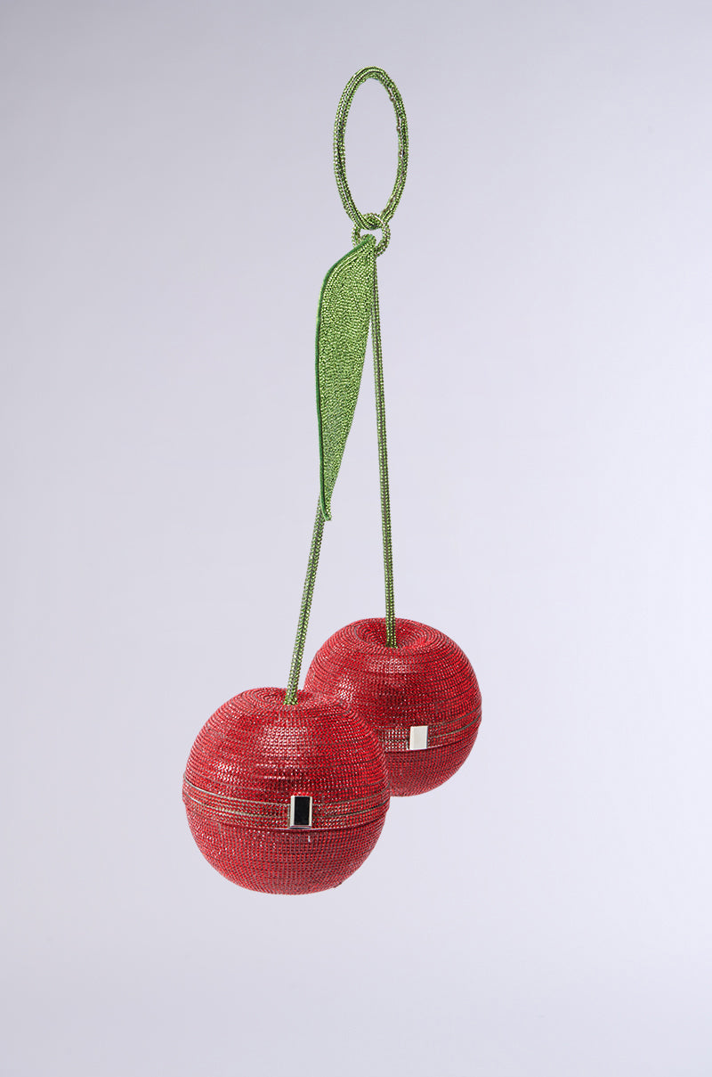 Introducing the POP MY CHERRY PURSE, a novelty handbag resembling cherries with green stems and a leaf, adorned with red beads and rhinestone-embellished silver clasps for a striking look against white. 2