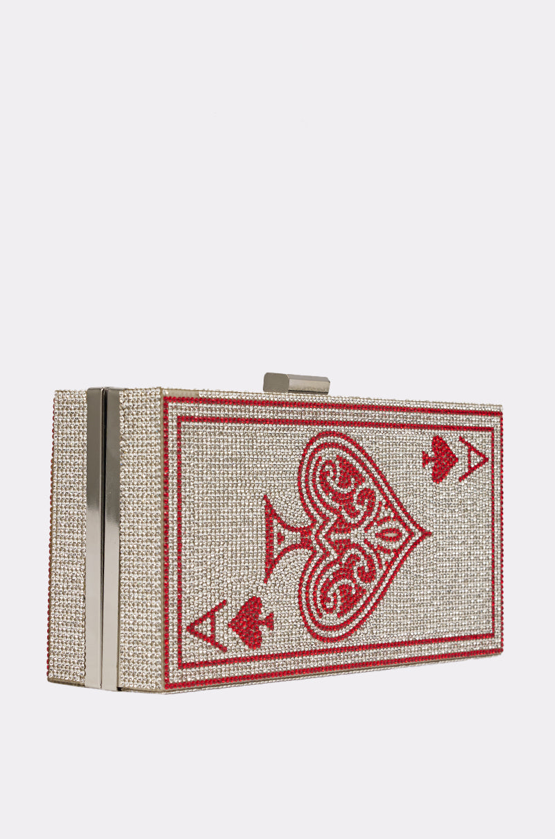 The PLAY YOUR CARDS CLUTCH is a rectangular evening bag with sparkling gems, styled to look like the Ace of Hearts playing card in bold red and silver. 2
