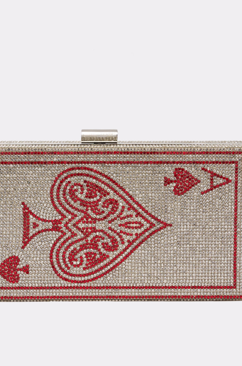 The PLAY YOUR CARDS CLUTCH is a rectangular rhinestone bag featuring a dazzling red ace of hearts card design on the front. 4