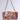 The ITS REALLY SWEET PURSE is a sweet shoulder bag flaunting a colorful floral tapestry and adorned with metal studs. It offers easy carrying with a chunky silver chain strap, set against a plain light gray background.