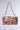 The ITS REALLY SWEET PURSE is a sweet shoulder bag flaunting a colorful floral tapestry and adorned with metal studs. It offers easy carrying with a chunky silver chain strap, set against a plain light gray background.