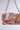 The ITS REALLY SWEET PURSE boasts a colorful floral pattern, silver chain handles, and metallic studs. It features a charming rose print set against a plain light gray background.