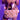 A person holds the BEAR WITH ME PURSE, a faux fur handbag with plush bear appliques, while wearing colorful rings and a dress of chains and charms. They pose against a softly lit purple background.