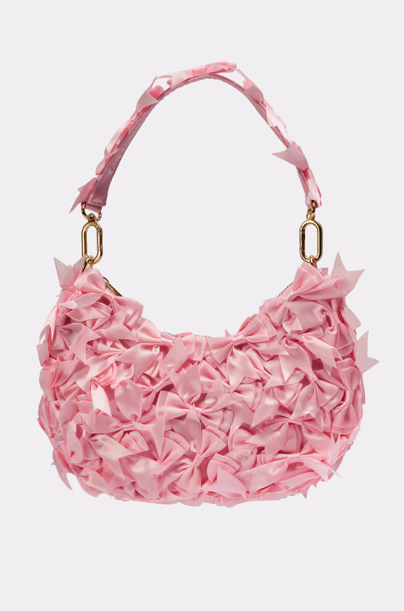 The BOWTIFUL PURSE in pink features a short handle, textured ruffled fabric for a floral effect, and elegant gold hardware with a zipper closure, making it a standout accessory. 2