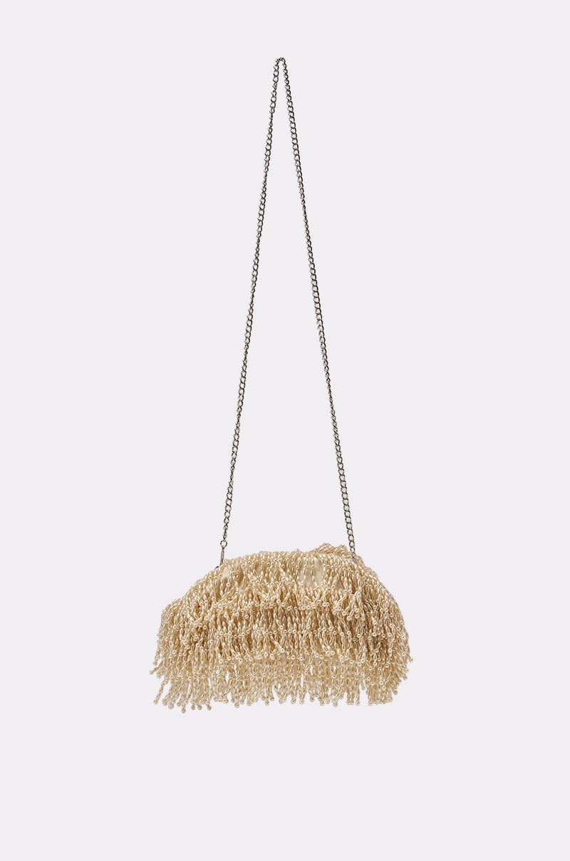 The ON AN ISLAND PEARL CLUTCH, a small beige bag with beaded pearl fringe and a thin metal chain strap, hangs against a white background—ideal as an elegant evening or wedding accessory. 3
