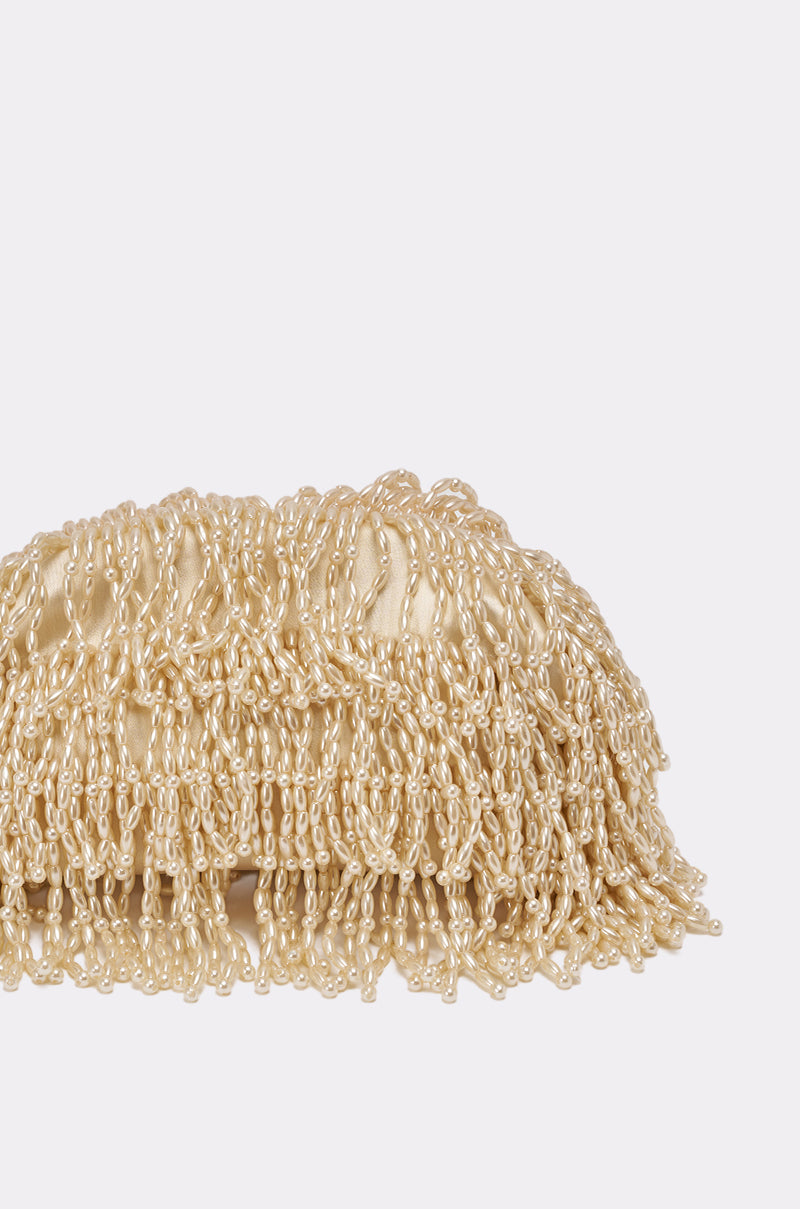 The ON AN ISLAND PEARL CLUTCH is a rectangular beige evening bag with a shiny textured surface and looped fringe, making it an elegant wedding accessory. Shown on a plain white background. 5