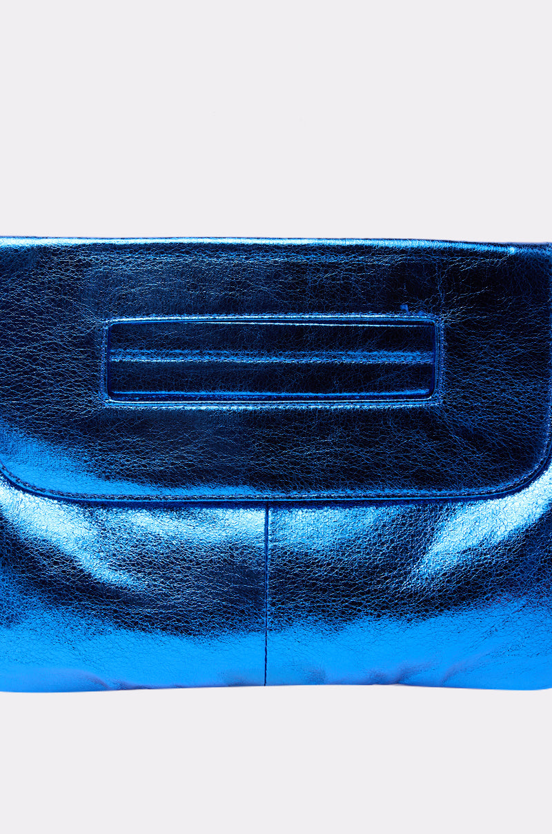 The COSMIC COBALT OVERSIZED CLUTCH features a shiny metallic blue finish and a rectangular handle slot, shown against a plain white background.