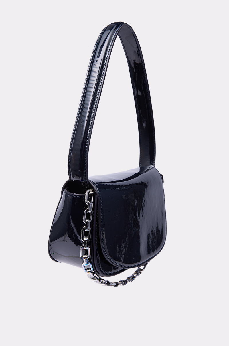 The WITH IT PATENT PURSE is a compact, glossy black mini bag made from faux patent leather with a wide shoulder strap and silver chain detail, shown against a plain light background. 2