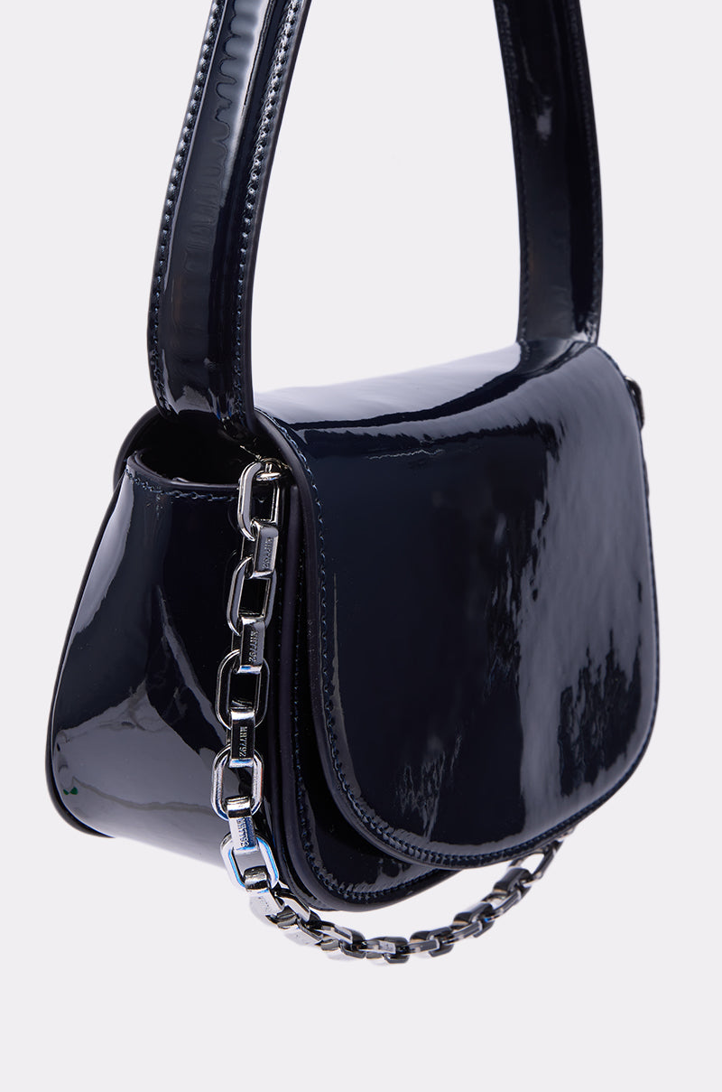 The WITH IT PATENT PURSE is a small, glossy black bag featuring a wide strap and silver chain detail on the front, shown against a plain light background. 3