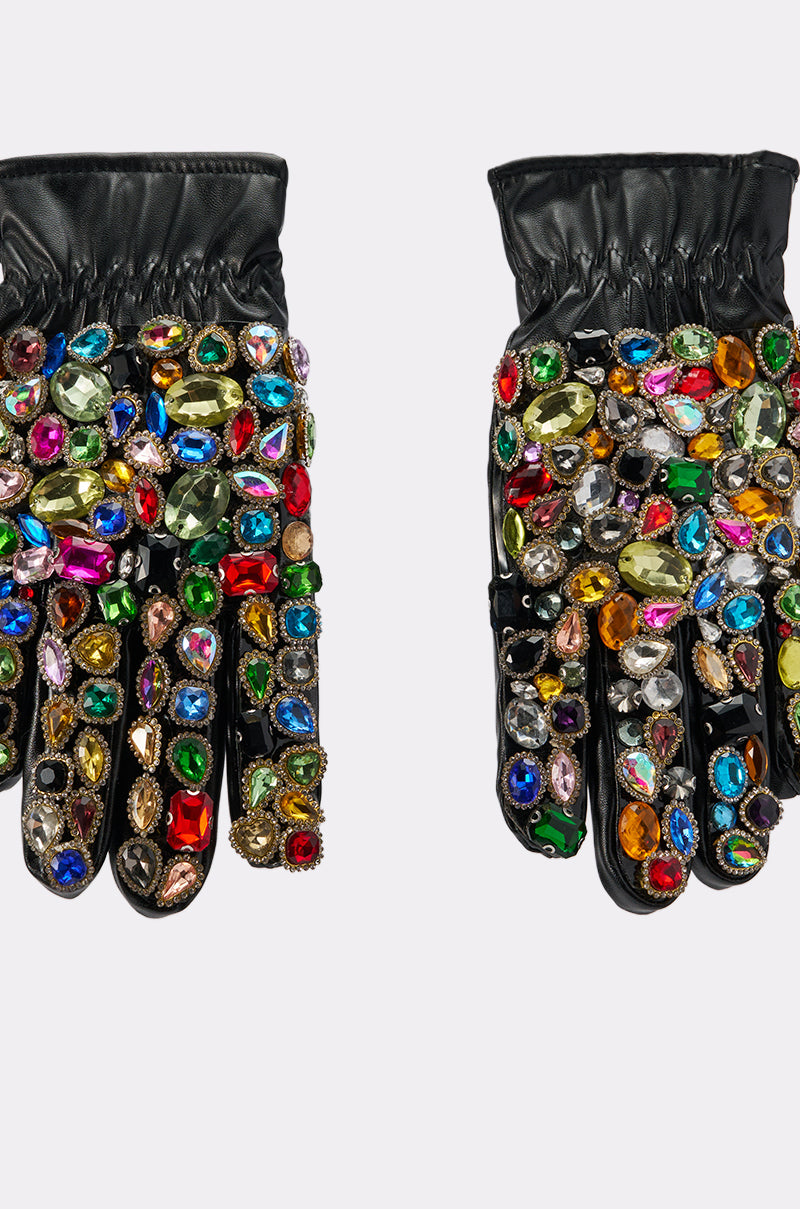 LOVE YOU BLING GLOVES: Black faux leather gloves adorned with large, colorful gemstones in various shapes, densely covering the fingers and backs, displayed on a plain light background.