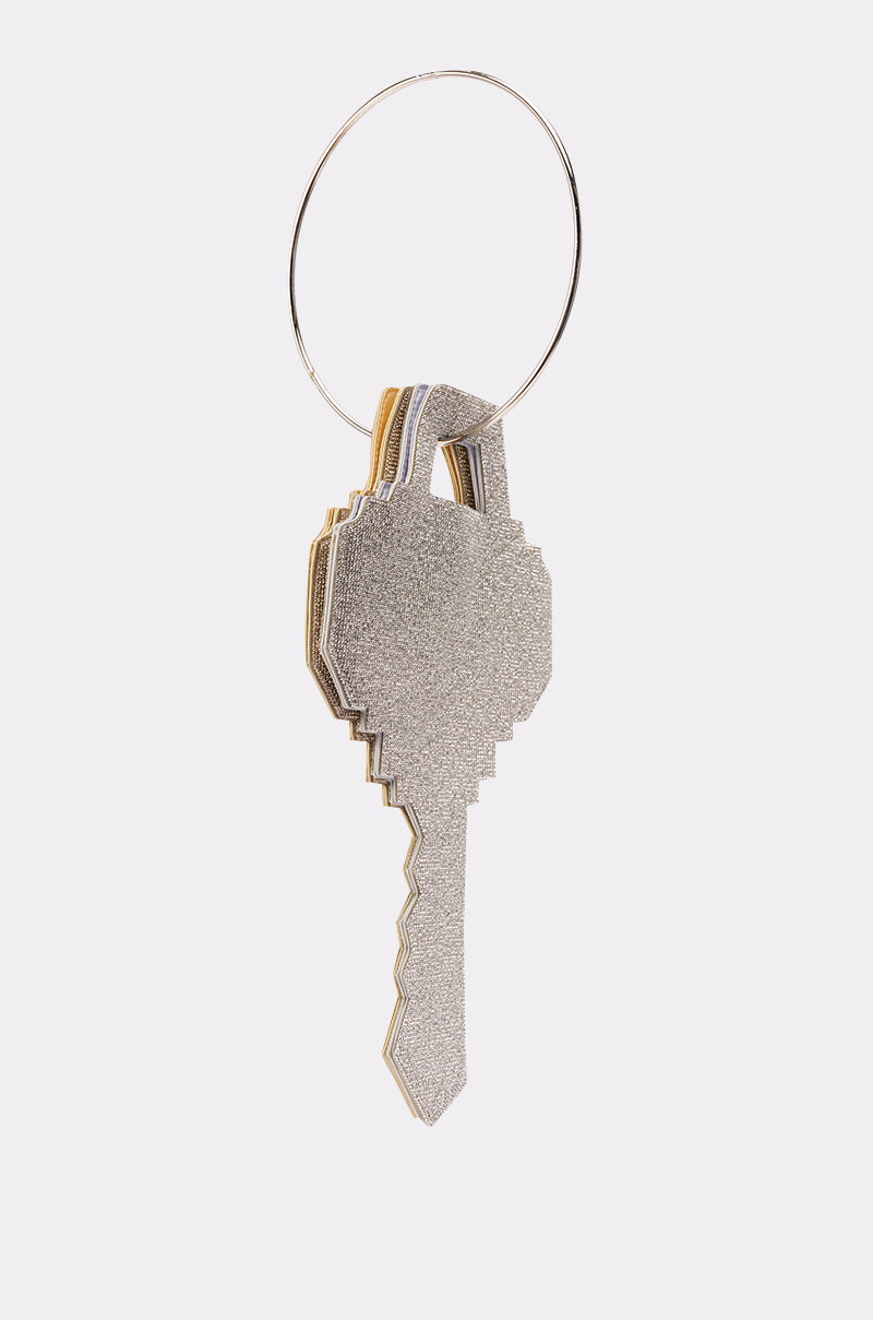 The I AM THE KEY OVERSIZED BLING BAGS keychain features a metallic, pixelated key shape with a glittery finish, sparkling like rhinestones as it hangs from a circular keyring against a white background. 0