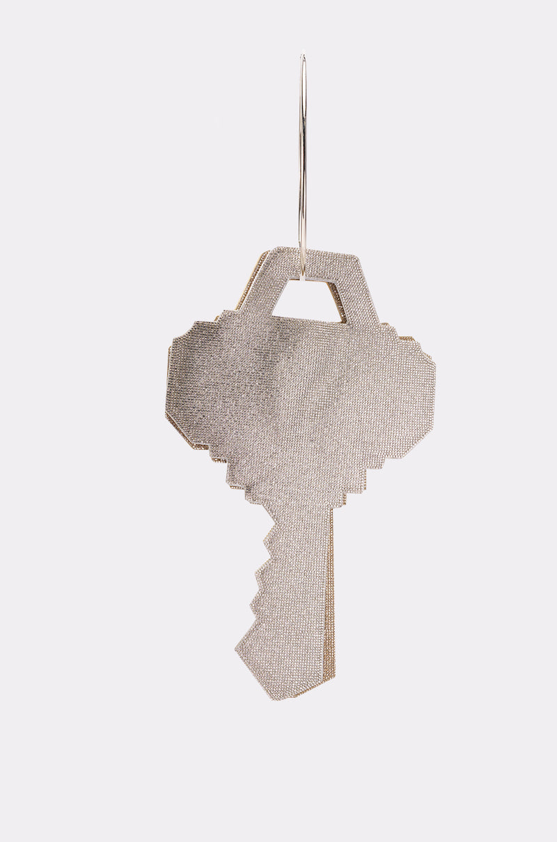 The I AM THE KEY OVERSIZED BLING BAGS earring features a metallic, pixelated key design hanging from a thin wire hoop, displayed against a plain white background. 2