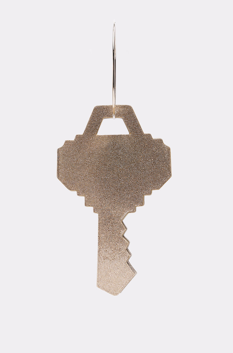 Showcased against a plain white background, the "I AM THE KEY OVERSIZED BLING BAGS" earring features a gold, pixelated key design inspired by a key-shaped purse. 3