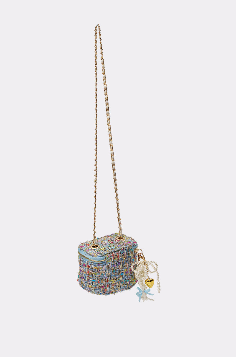 The I HAVE CLASS TWEED PURSE is a small pastel crossbody bag with a gold chain strap, zip closure, and a decorative pearl charm accented by a gold heart on the side. 3