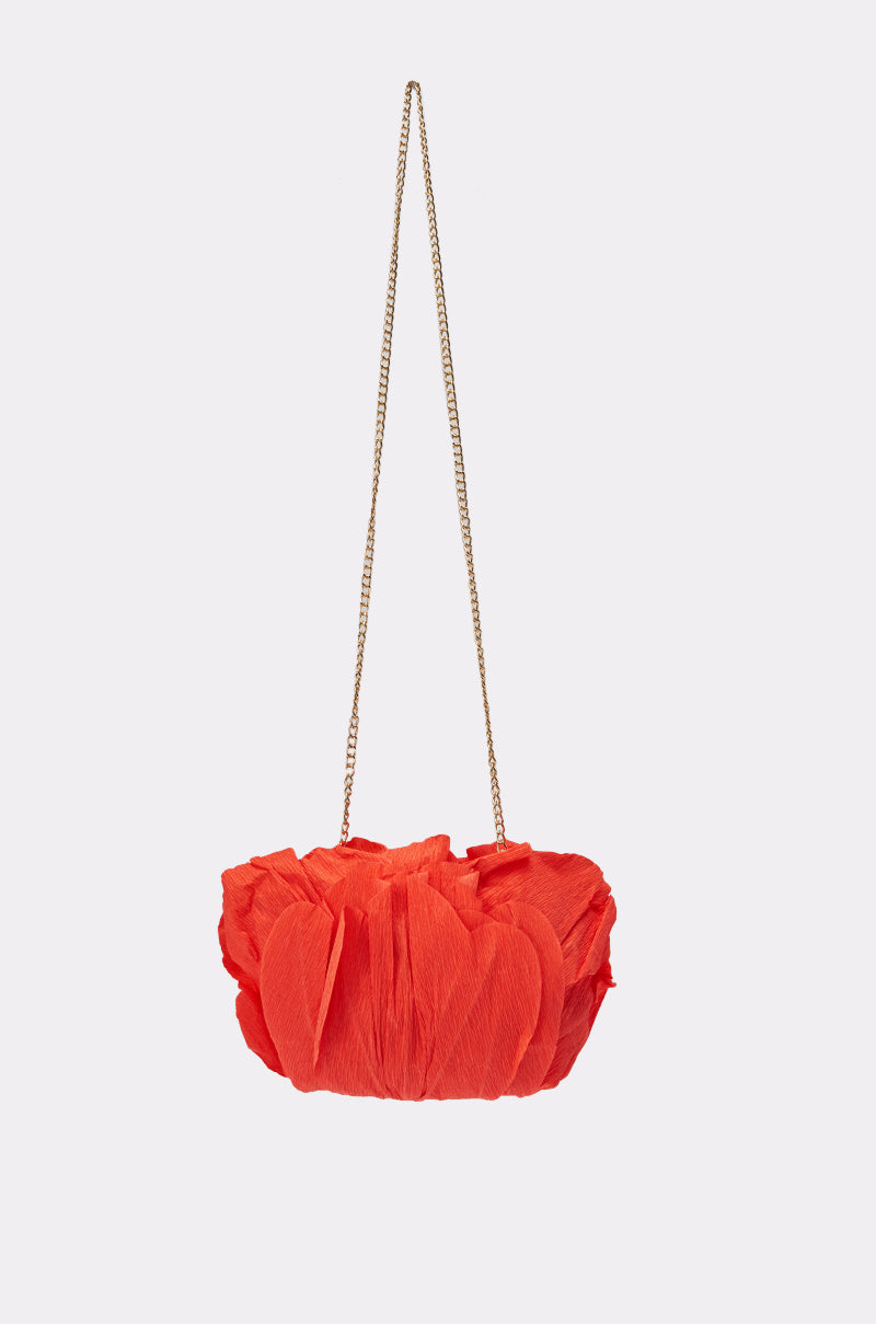 The FEEL MY VIBE CLUTCH is a small, bright red evening bag featuring textured petal-like details and a thin gold chain strap, displayed against a plain light background. 2