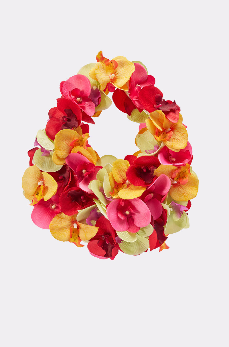 The ORCHID LOVE PURSE features a dense arrangement of vibrant artificial red, yellow, pink, and green flowers for a bold, colorful summer accessory. Displayed against a plain white background. 1