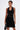 A person with short hair and tattoos models the EDGY AND COOL LACE UP KNIT MINI DRESS, holding a black handbag against a plain white background.