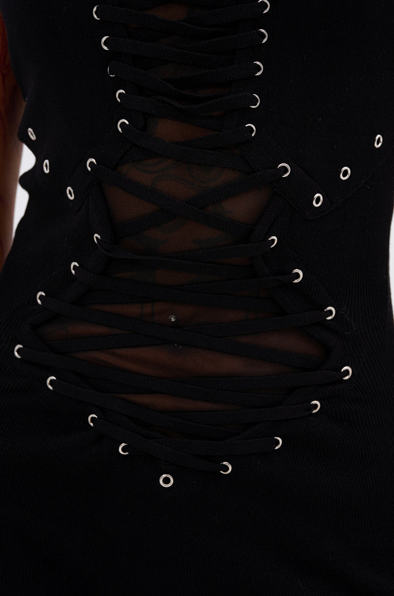 Close-up of the EDGY AND COOL LACE UP KNIT MINI DRESS in black, featuring silver eyelets, sheer mesh fabric underneath, and a fitted bodycon silhouette.
