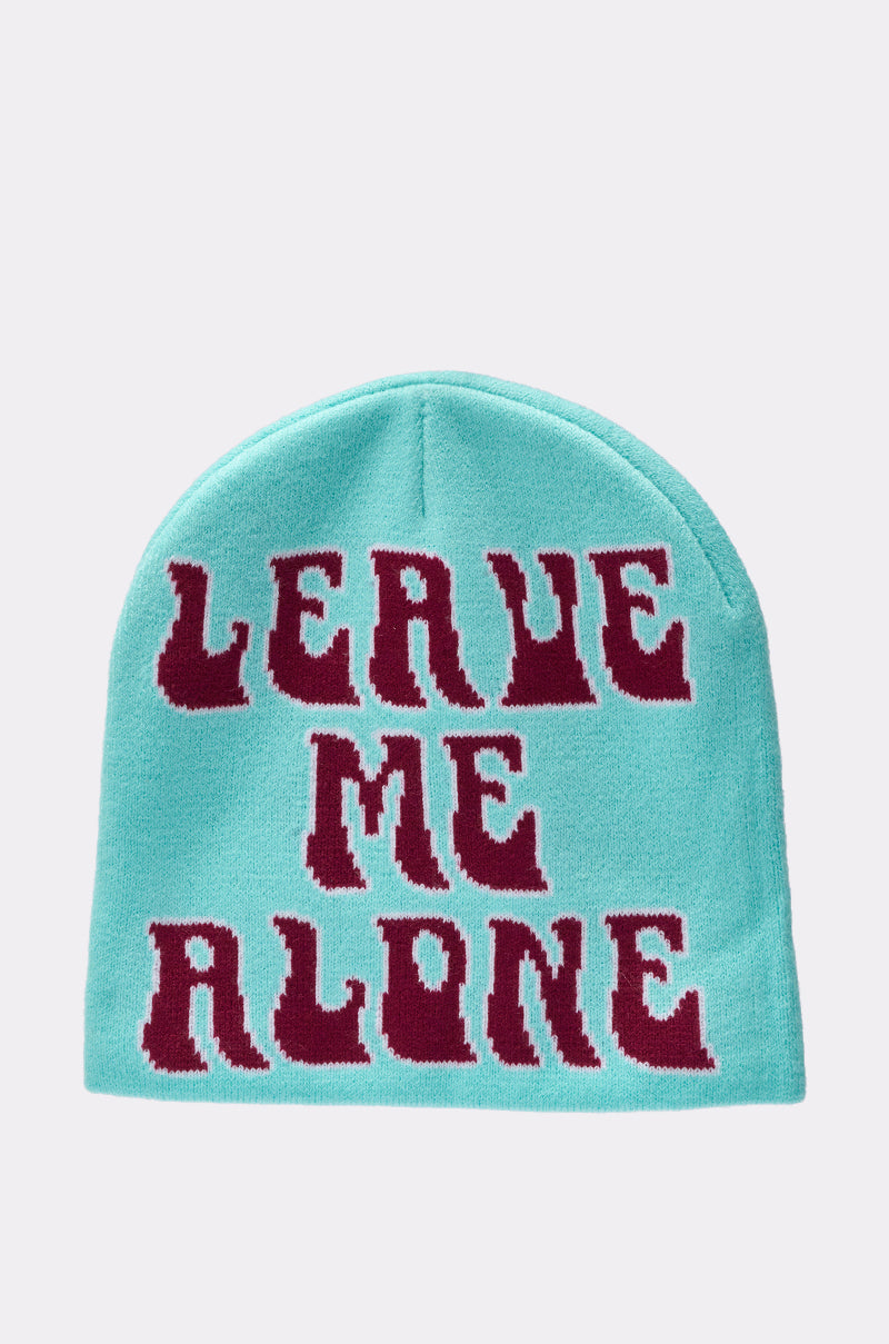 The LEAVE ME ALONE BEANIE is a light blue knit beanie featuring bold dark red "LEAVE ME ALONE" text in a stylized font on the front—your go-to statement accessory. 1