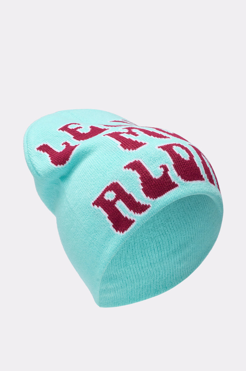 The LEAVE ME ALONE BEANIE features a light blue stretch knit with bold red "Leave Me Alone" text in a stylized font. Its slightly slouched back gives a relaxed vibe, shown against a plain light gray background. 3