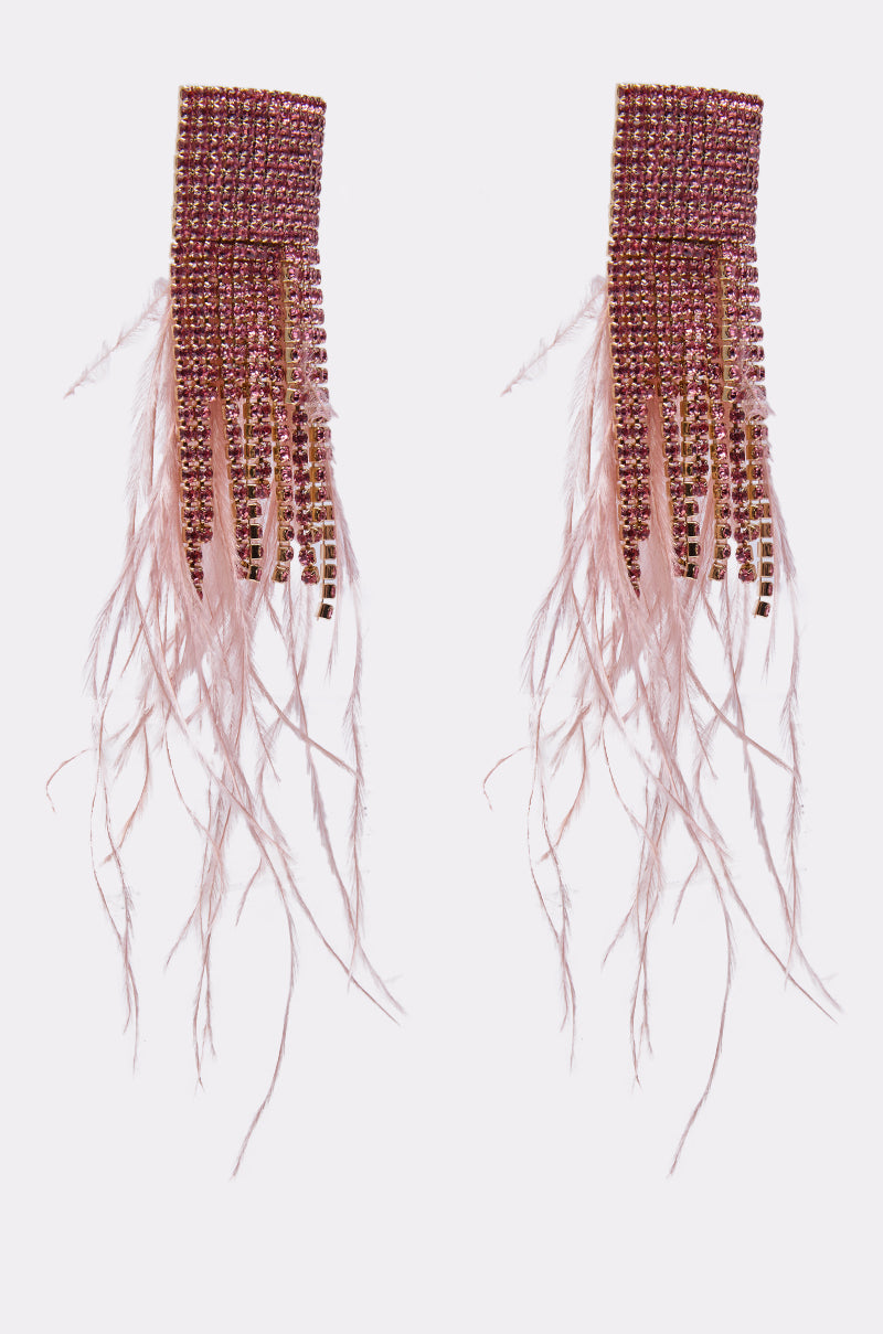 The SHAKE IT EARRING features long, rectangular pink rhinestone earrings with sparkling stones and cascading pink feathers, displayed symmetrically on a plain white background. 4