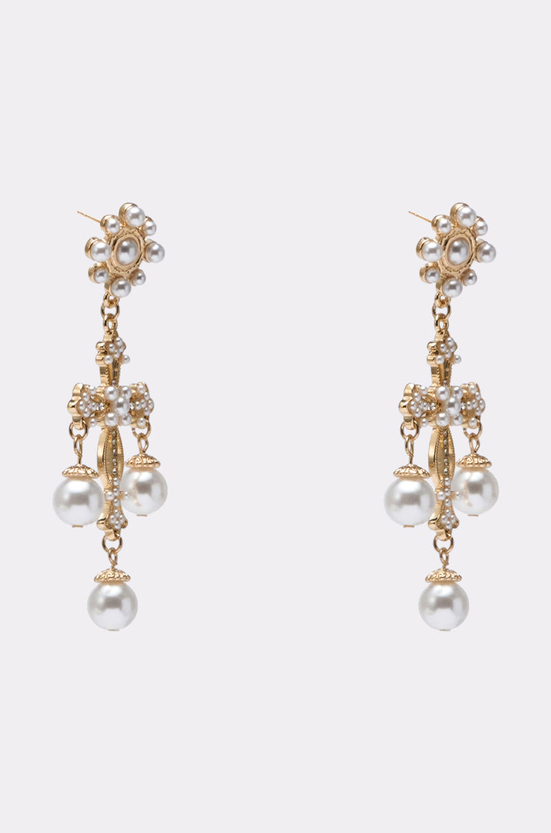 CROSS IT OUT EARRING: Gold-tone chandelier earrings featuring clusters of small white pearls and three larger dangling pearls, displayed against a plain light background. 3