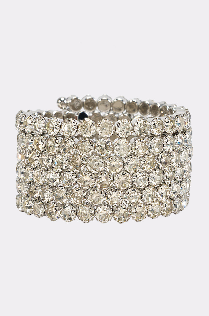 Introducing the CRYSTAL WRAP AROUND CUFF—a wide silver stretch bracelet embellished with multiple rows of closely set, sparkling clear rhinestones for a dazzling, textured look against a plain white background. This elegant crystal rhinestone arm cuff is the perfect choice to add glamour as a wedding guest bracelet or for any special occasion.