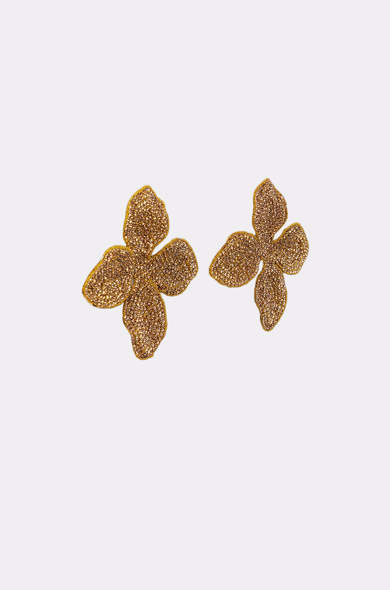 The GOLDEN GLAM EARRING features oversized, gold-toned earrings with a textured four-petal floral design, shown on a plain white background. 2