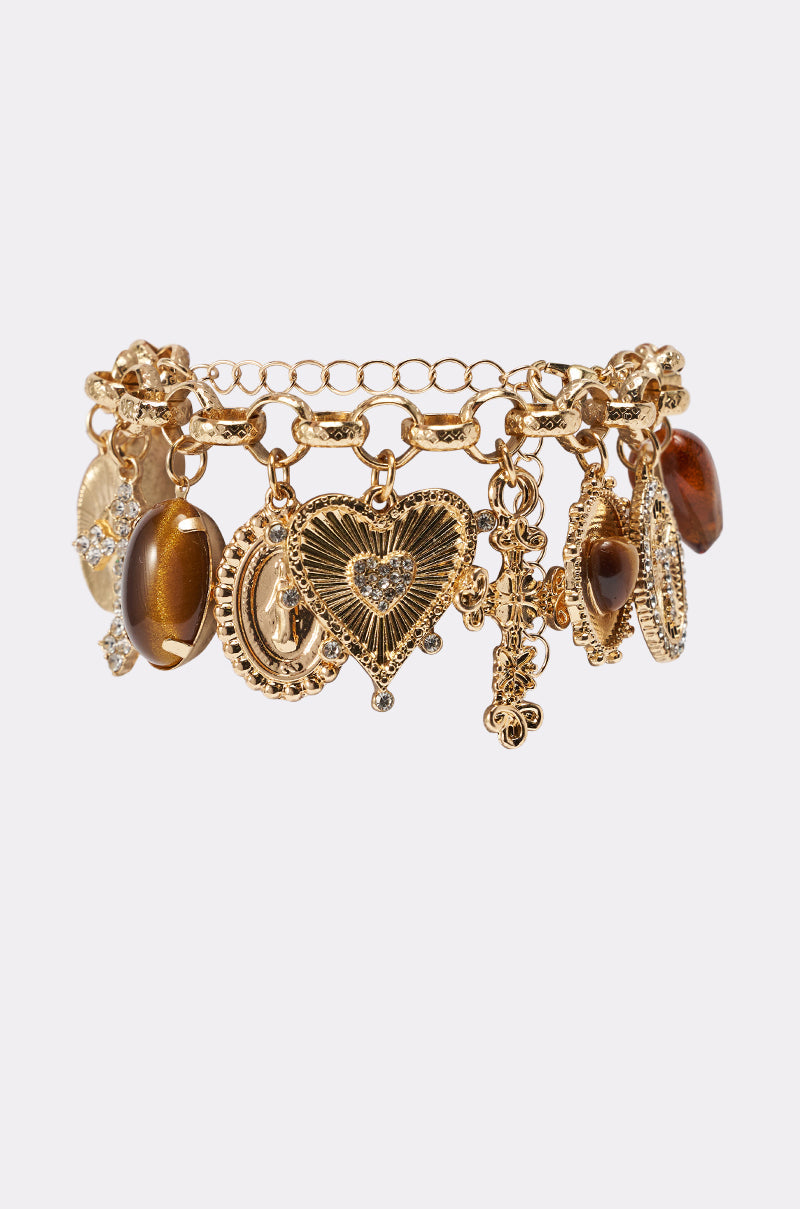 The CHARM IT UP BRACELET is a gold-tone, chunky link charm bracelet with vintage-inspired heart and oval stone charms, intricate designs, shown on a plain white background. 1