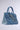 Introducing the Denim Blues Tote Purse, a stylish handbag crafted to resemble blue denim jeans. It features front pockets, belt loops, and silver hardware draped across the front. The purse boasts a jean waistband design and includes a top handle, set beautifully against a plain background.