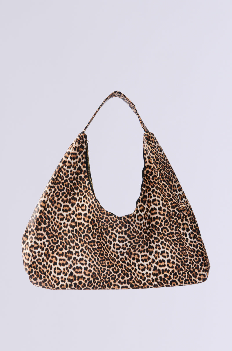 The WILD ONE PU OVERSIZED TOTE is highlighted against a plain backdrop, boasting its modern slouchy design in leopard print. This faux leather tote has a single strap, perfectly combining style with practicality.