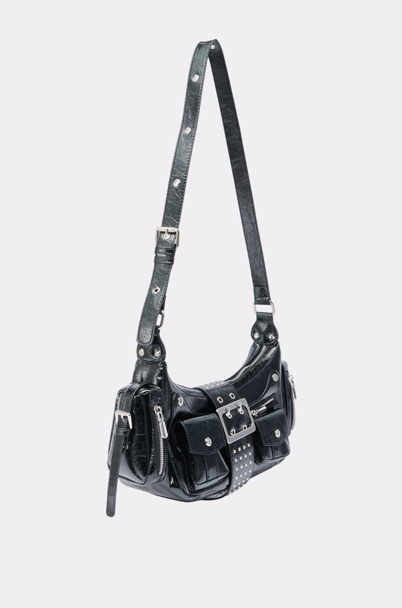 THE TIDUS PU PURSE is a black, streetwear-inspired shoulder bag with silver studs, zippers, a bold front buckle, multiple pockets, and an adjustable strap in a structured baguette silhouette shown against a plain white background. 4