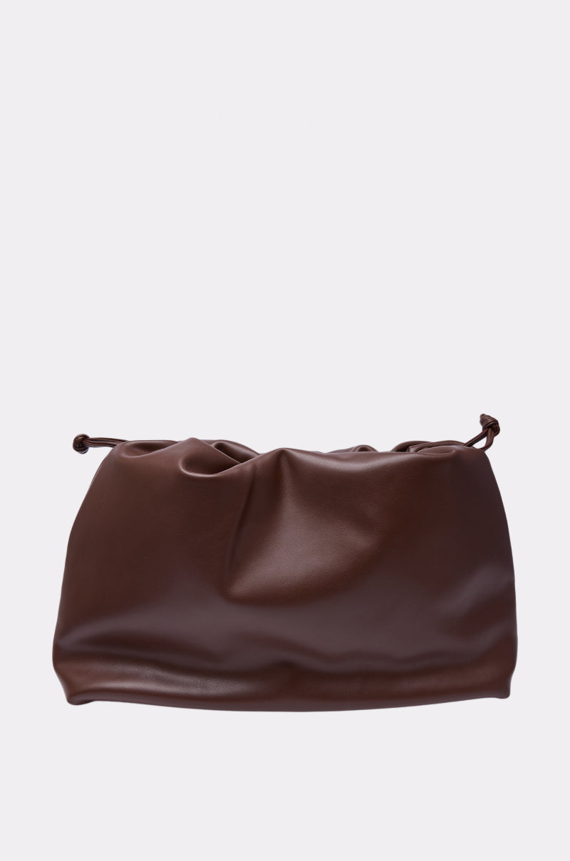 The IN PARIS WITH IT PURSE is a large, soft brown leather drawstring clutch with a ruched top, displayed against a plain white background. 2