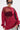 A woman wears the OPEN FOR BUSINESS SWEATSHIRT IN BURGUNDY with rhinestone mesh paneling over a black sequin bra, styled with light-wash ripped jeans, black sunglasses, a black shoulder strap, short dark hair, and a confident look.