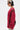 A person with short black and blonde hair, sunglasses, and earrings stands in profile against a white background, wearing the loose-fitting OPEN FOR BUSINESS SWEATSHIRT IN BURGUNDY from AKIRA Label with rhinestone mesh paneling.