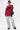 A person confidently poses against a white background wearing the OPEN FOR BUSINESS SWEATSHIRT IN BURGUNDY with rhinestone mesh paneling, light-wash cargo jeans, black platform shoes, dark sunglasses, and a black crossbody bag.