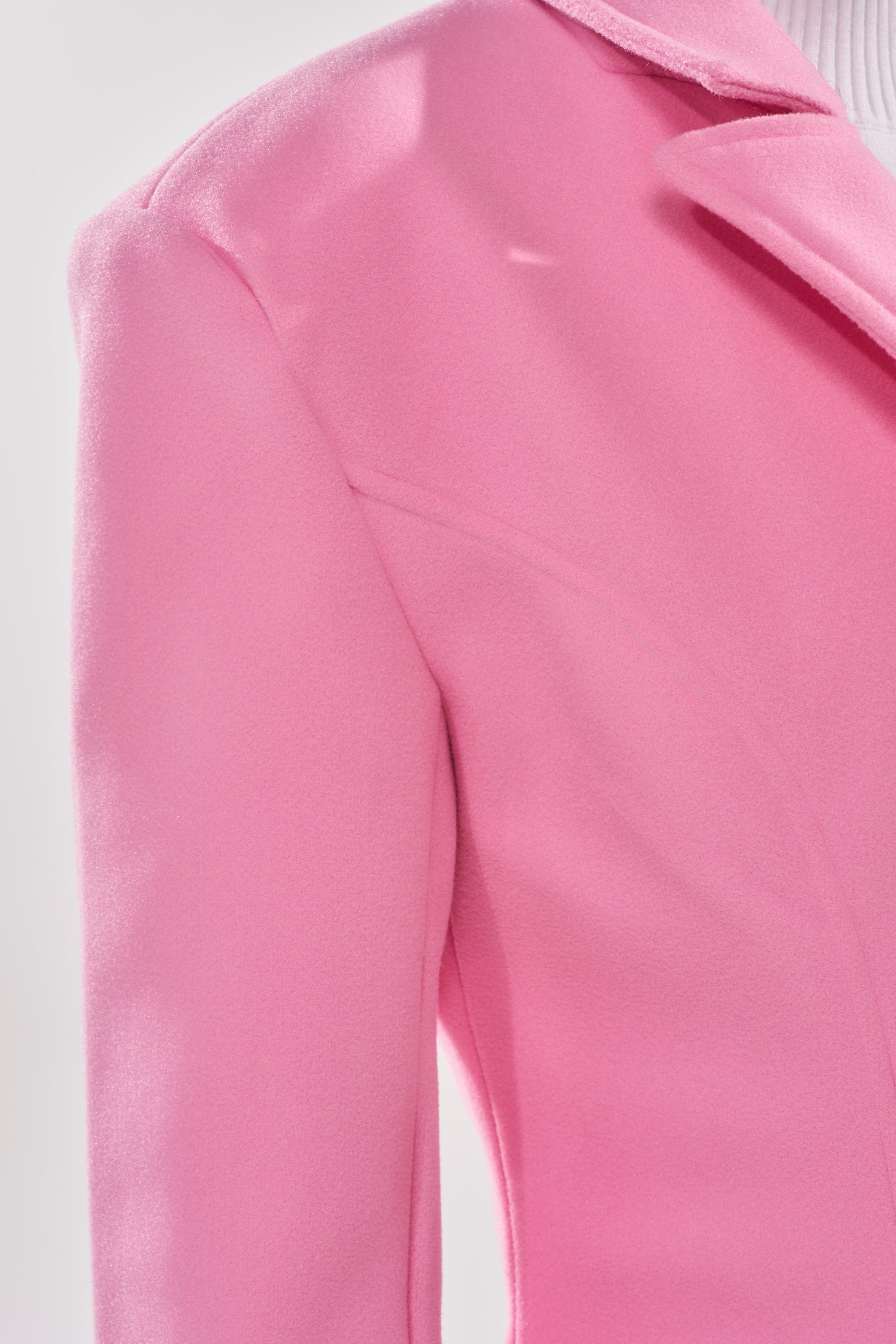 Close-up of a person wearing the SWEET THING WOVEN TRENCH, highlighting its tailored shoulder, lapel, and upper sleeve details against a light background. 6