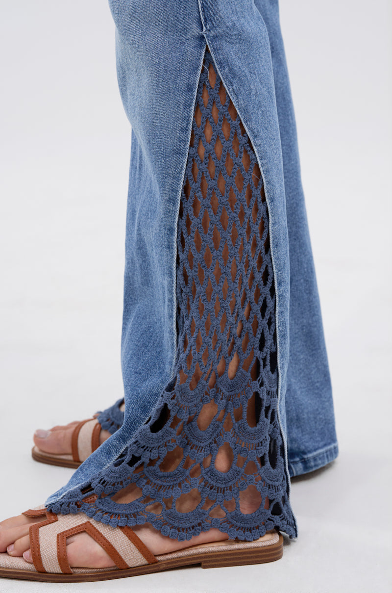 A side view shows a person wearing SUMMER DAYS RELAXED DENIM WITH EYELET OPENING, featuring relaxed mid-rise jeans with wide crochet side panels, paired with brown strappy sandals against a plain background. 6