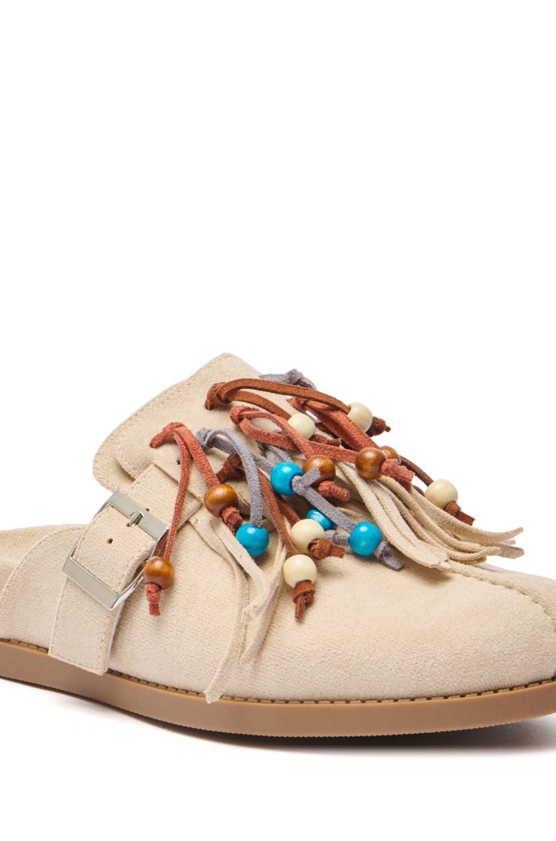 The AZALEA WANG ABEILLE Beige Faux Suede Fringe Clog features a silver buckle and multicolored leather laces with turquoise, brown, and cream beads—perfect boho shoes for a laid-back look.