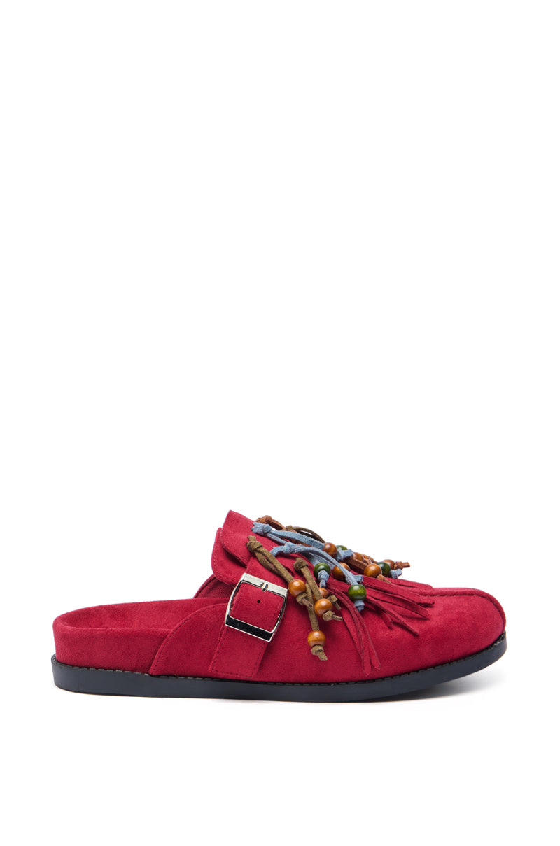 The AZALEA WANG ABEILLE BURGUNDY FAUX SUEDE FRINGE CLOG is a bohemian slip-on with a black sole, side buckle, multicolored beads, and burgundy fringe on the upper front.