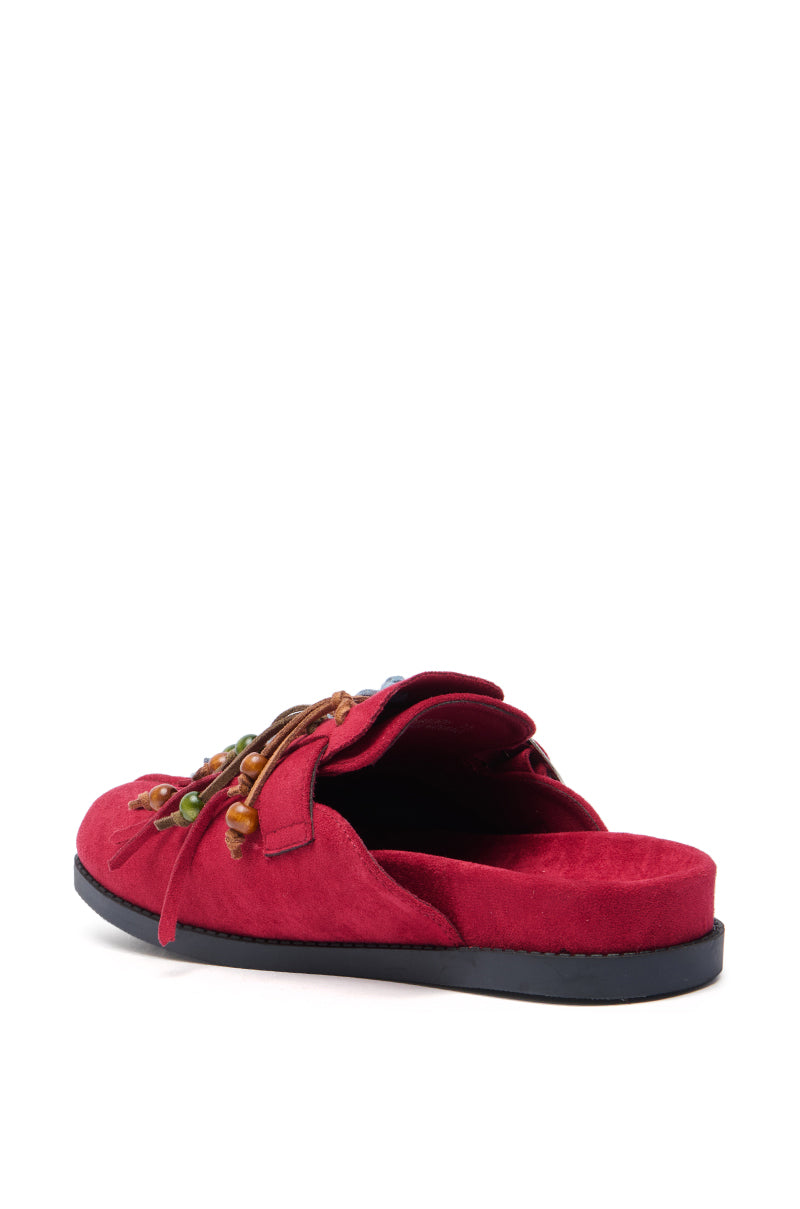 The AZALEA WANG ABEILLE Burgundy Faux Suede Fringe Clog features a black sole, multicolored beads, and brown laces. Photographed at an angle, it highlights bohemian style with detailed inside and side views against a white background.