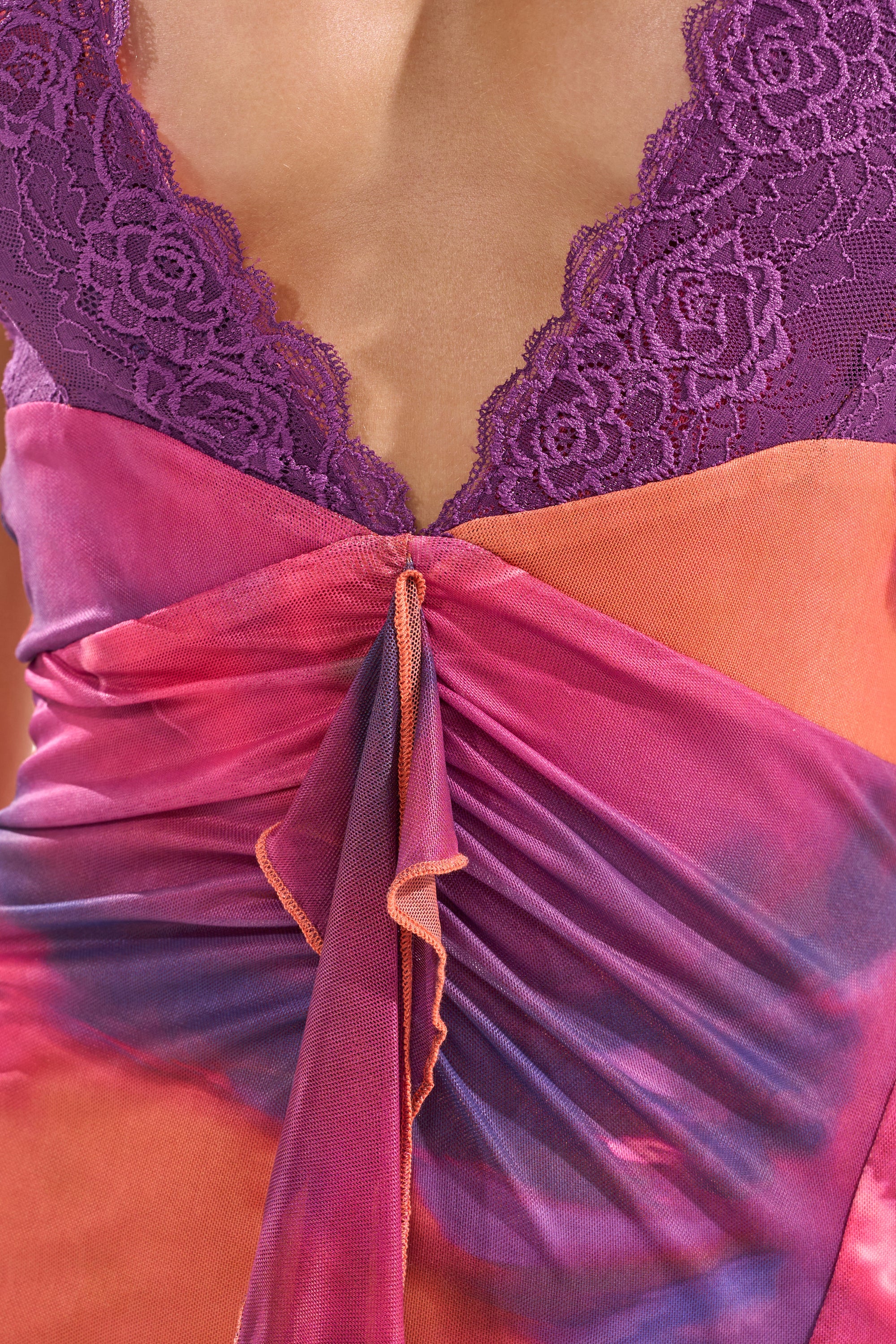 Close-up of the MI AMOR HALTER LACE MAXI DRESS, featuring a deep V neckline with purple lace trim and ruched, draped fabric in vibrant pink, purple, and orange—ideal for evening occasions. 4