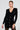 A woman wearing the SUSIE MINI DRESS IN BLACK, featuring a bodycon silhouette enhanced with embossed gold buttons, poses against a plain background. Her hair is styled back, and she's accessorized with large hoop earrings.